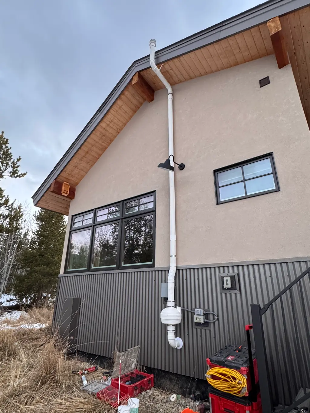Radon mitigation pipe and exhaust fan installed on the exterior of a Colorado mountain home