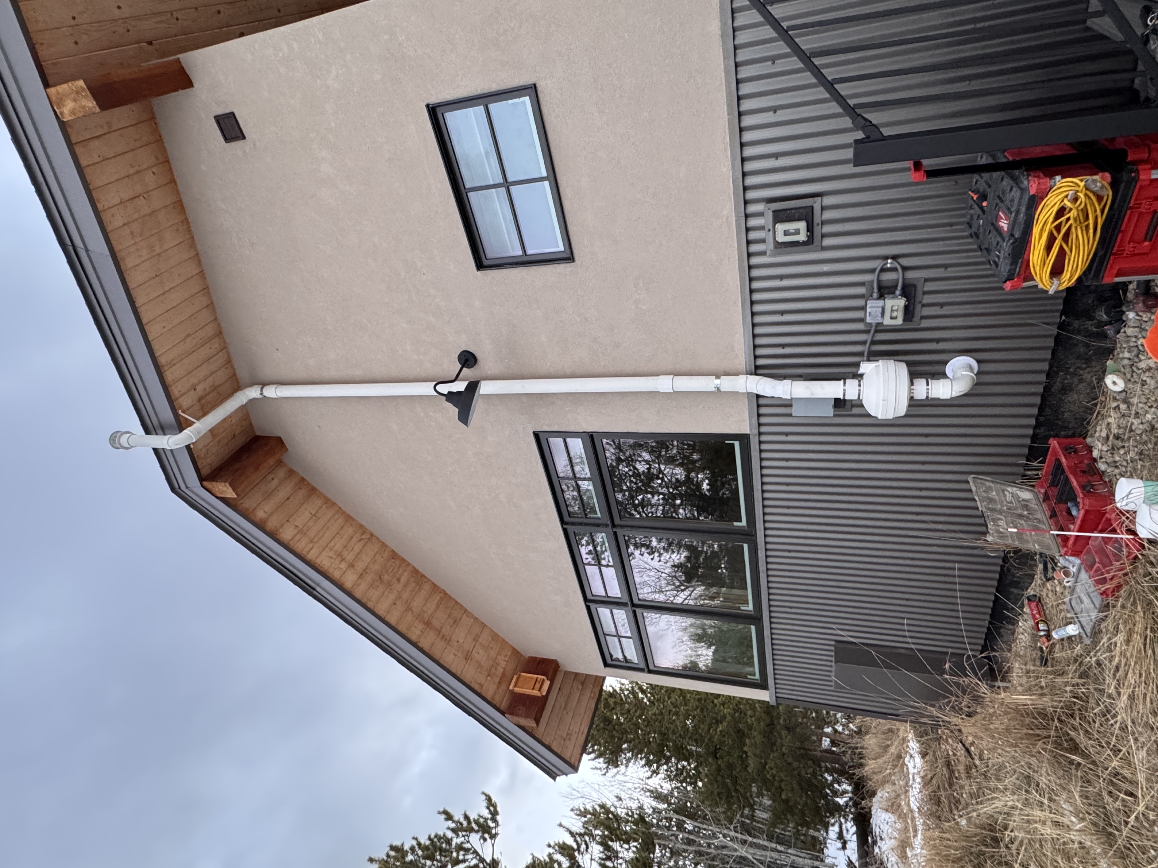Radon mitigation system installed on the exterior of a Colorado mountain home