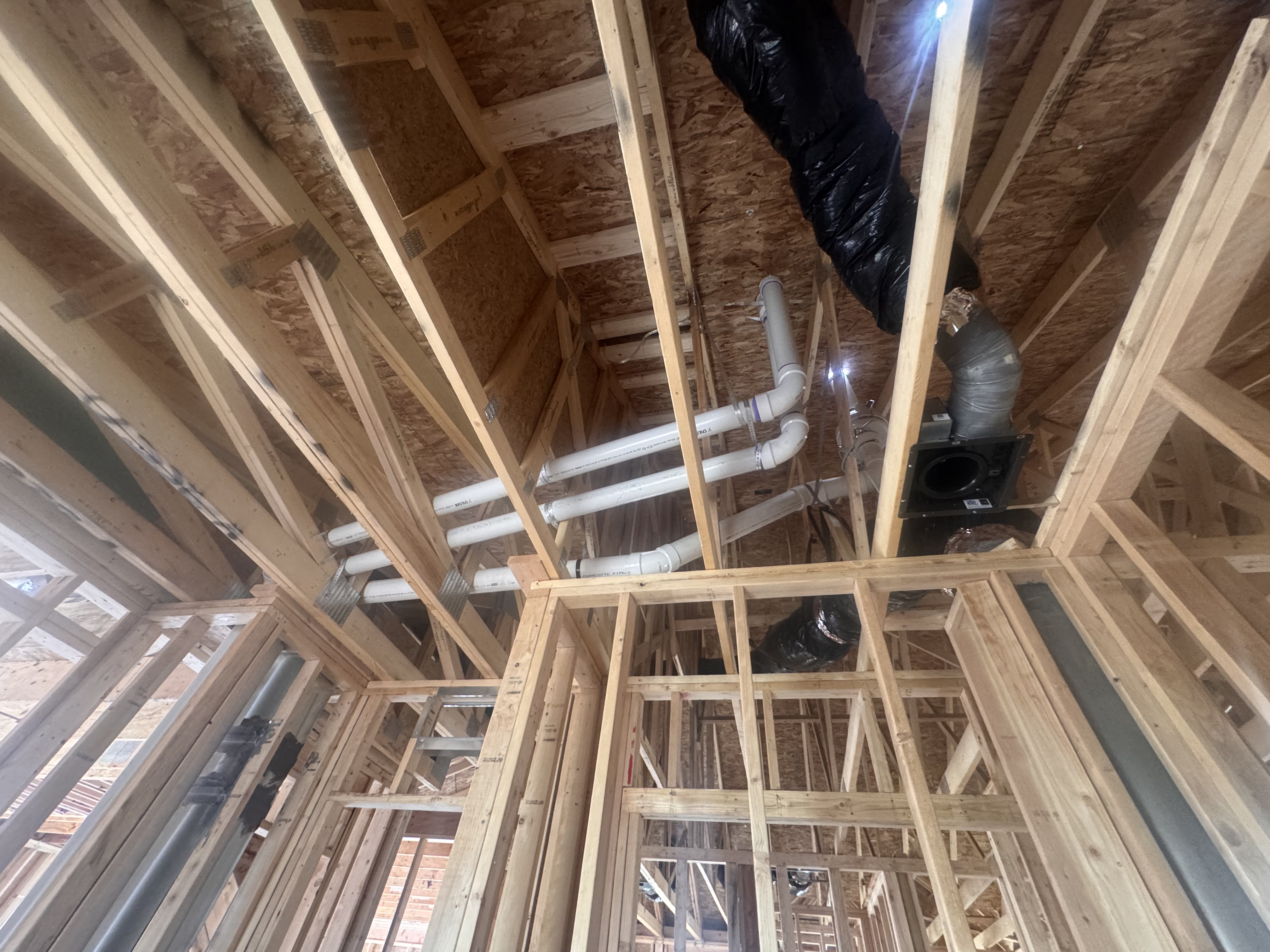 Radon piping routed cleanly through the trusses of a home under construction
