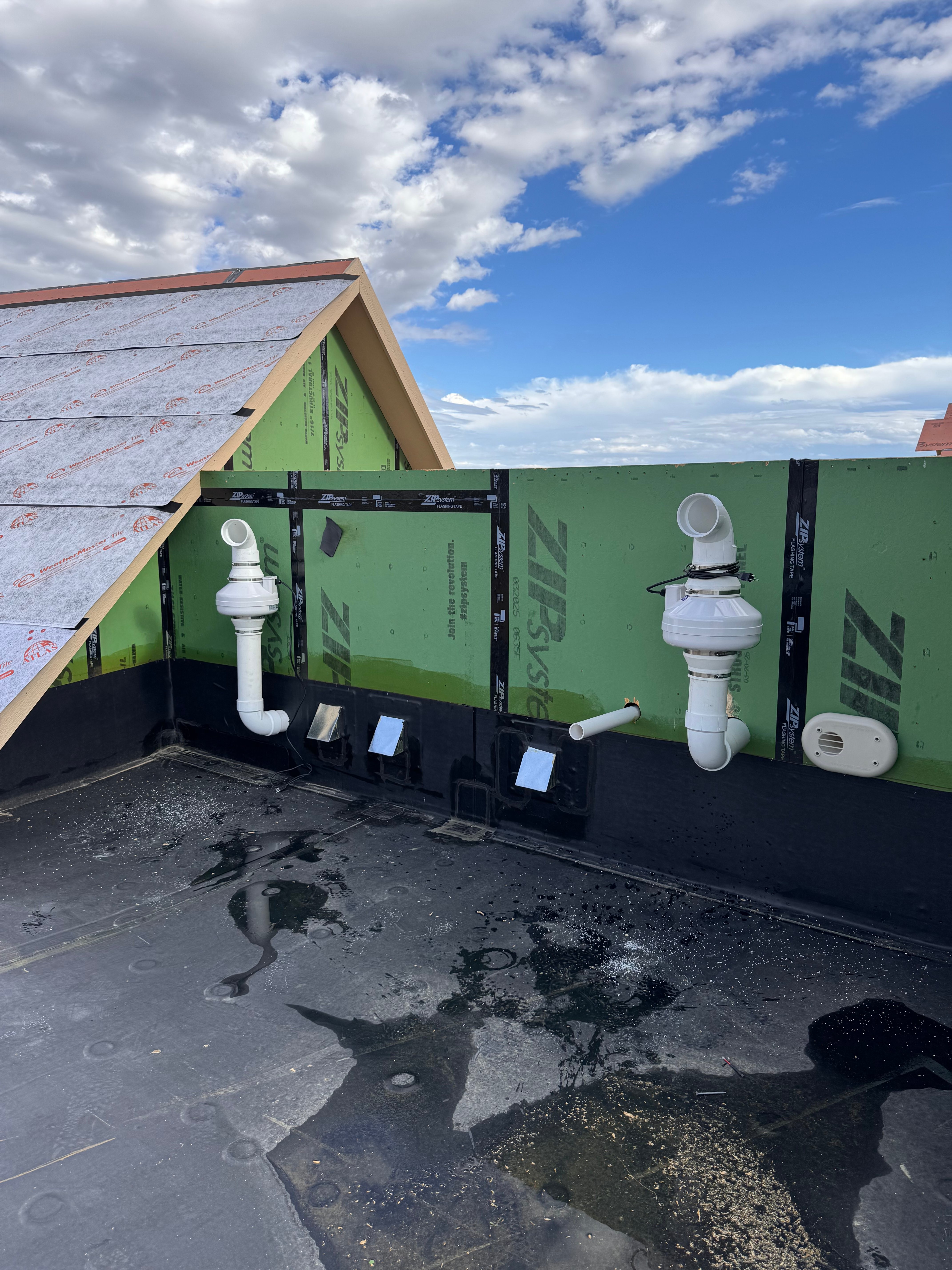 Radon exhaust fans venting above the roofline on a new build